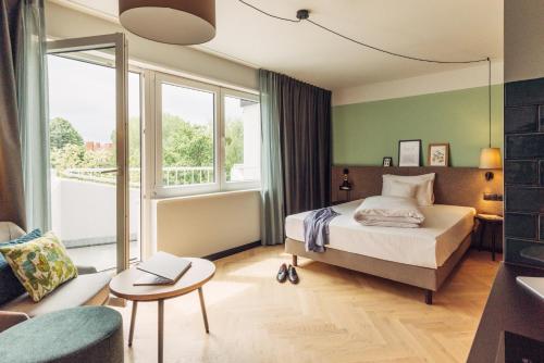 柏林harry's home Berlin-Moabit hotel & apartments的卧室配有1张床、1张桌子和1把椅子