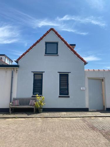 滨海卡特韦克Guesthouse Katwijk aan Zee的前面有长凳的白色房子