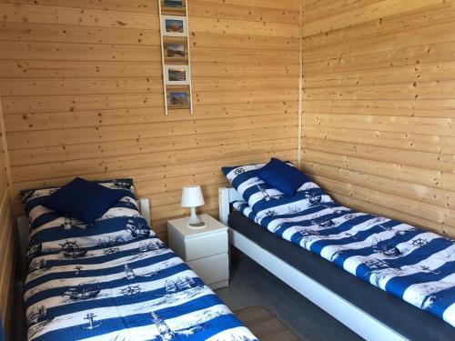 里沃Domki Wypoczynkowe "Sea Breeze"的木墙客房的两张床