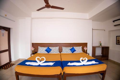 蓬蒂切里VKG Hotels的一间卧室配有一张带两个天鹅的床