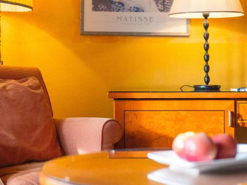 翁根Hotel Silberhorn - Residences & Spa Wengen的一张桌子,上面有一盏灯和一盘苹果