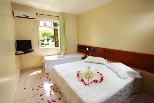 塞古罗港Apart Hotel Boulevard da Praia - Portal Hotéis的一间卧室,配有一张插花的床
