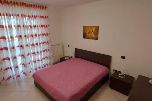 巴列塔Casa vacanze Margherita的一间卧室配有一张带粉色毯子的床