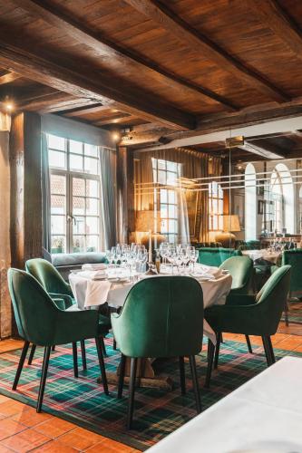 布鲁日De Goedendag的一间带桌子和绿色椅子的用餐室