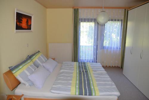 阿尔布斯塔特Ferienwohnung Dürnbach的卧室设有一张白色大床和两个窗户。