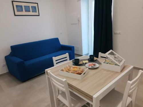 伊斯基亚Casa Verdemare的客厅配有桌子和蓝色沙发