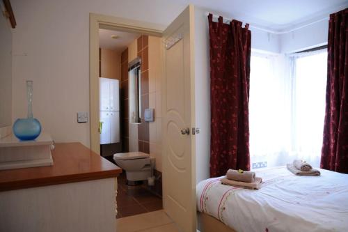 基拉尼Killarney , Ring of Kerry 2 Bed Apartment 2 Bathrooms的一间卧室配有一张床,浴室设有卫生间