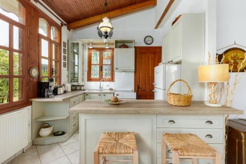 帕拉塔蒙Sevi's Holiday Home, Panel Hospitality Homes & Villas的厨房配有白色橱柜和带凳子的台面