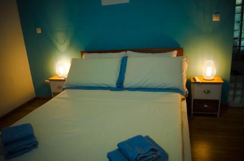 塔那那利佛Room in Villa - The blue room is an accent of modernity in the silence of the surrounding garden的一间卧室配有白色床和2个床头柜