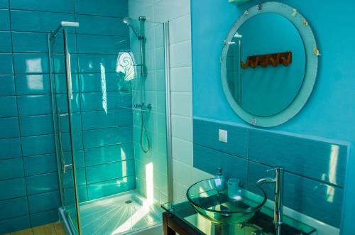 塔那那利佛Room in Villa - The blue room is an accent of modernity in the silence of the surrounding garden的蓝色的浴室设有玻璃水槽和淋浴