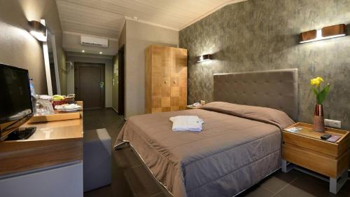 波托什Atrium Hotel Thassos的一间卧室配有一张大床和电视