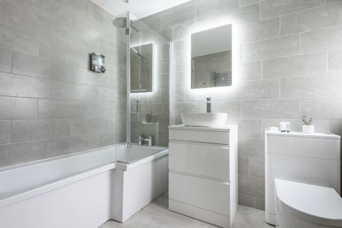 纽基Spacious, Modern Home, Central Newquay w/ parking的一间带水槽、浴缸和卫生间的浴室
