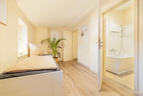 施特拉尔松德Ferienappartements Stralsund的一间卧室配有一张床,浴室设有浴缸