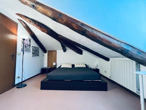 都灵Attico Porta Nuova, Torino Centro的一间带一张床的卧室,位于带木制天花板的房间内