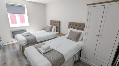 利物浦科库国际酒店公寓的一间卧室设有两张床和窗户。