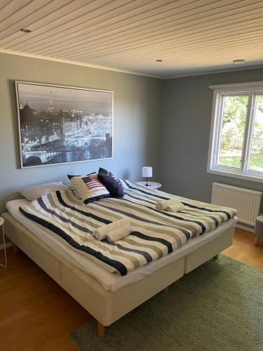 莫勒松德Trevligt hus i mysiga Mollösund Tången的卧室配有一张大床,墙上挂有绘画作品
