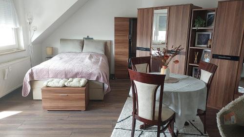 莱比锡StayInn Möckern - 1 Zimmer Apartment für 3 Personen的卧室配有一张床和一张桌子及椅子