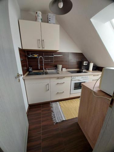 莱比锡StayInn Möckern - 1 Zimmer Apartment für 3 Personen的一间小厨房,配有白色的橱柜和楼梯