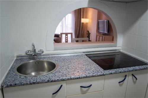 贝纳尔马德纳Mar del Sur Apartment Sea Views的厨房里的一个水槽,上面有镜子