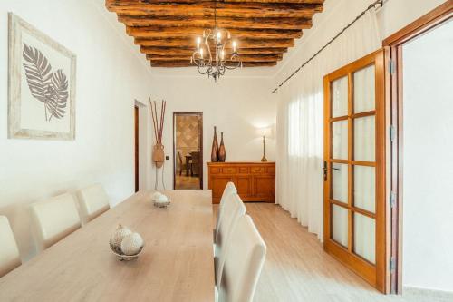 波蒂纳茨Finca Norte, Amazing villa close to the best Beaches的一间带木桌和白色椅子的用餐室