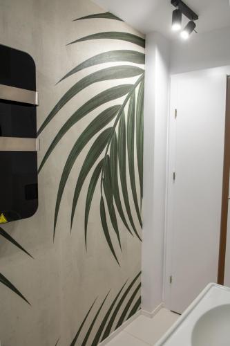 布加勒斯特Andor apartment near park and subway的浴室墙上挂着棕榈树壁画