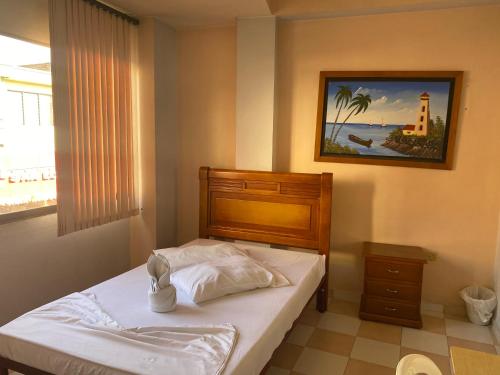 图卢阿Hotel Los Corales Tulua的卧室配有一张床,墙上挂着一幅画