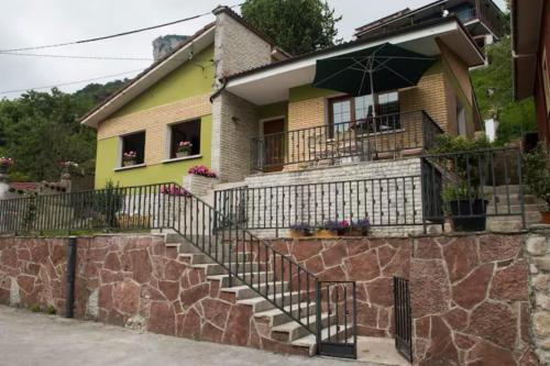 卡瑞纳Casa La Bolera的黄色房子,设有楼梯和雨伞