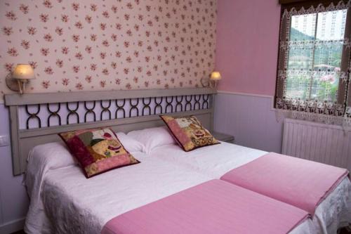 卡瑞纳Casa La Bolera的一间卧室配有一张带两个枕头的床