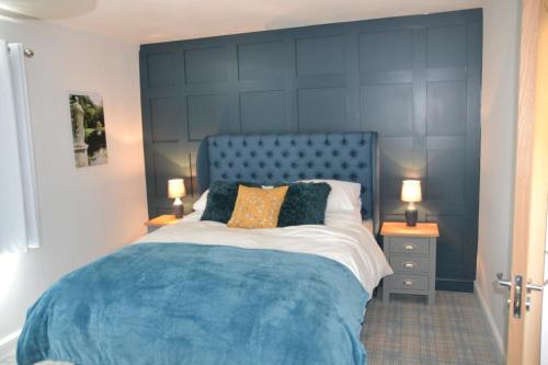马斯顿The Thorold的卧室里一张带蓝色床头板的床