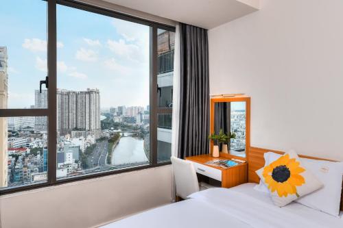 胡志明市April Apartment的一间卧室设有大窗户、一张床和一张书桌