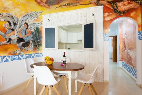 拉奥罗塔瓦EDEN RENTALS La Morada de Otazzo的用餐室配有桌椅和壁画