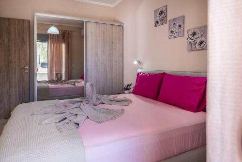 阿彻奇洛斯Extreme House的卧室配有带粉红色枕头的大型白色床