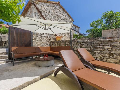 拉宾Holiday Home Casa Di Nelo by Interhome的庭院设有2张长椅和遮阳伞。