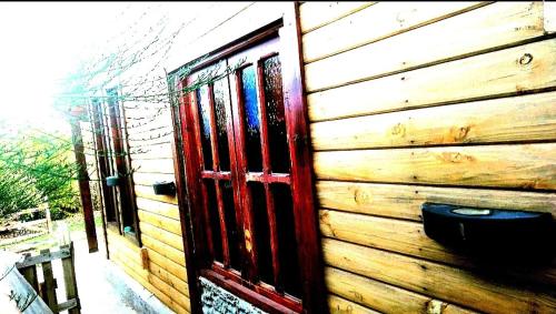 埃尔卡拉法特Cabaña Onty的一间木房子,旁边设有一扇红色的门