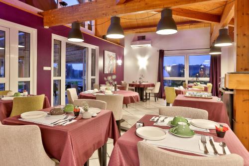 MaussacHôtel-Restaurant Logis Europa的餐厅拥有紫色的墙壁和桌椅