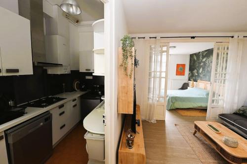 巴涅尔德比戈尔Appartement 2 à 4 pers cosy à proximité du centre的一间带白色橱柜的厨房和一间带一张床的房间