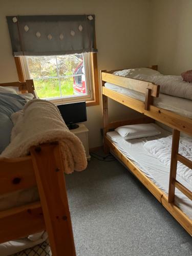 DrangedalLeilighet på Gautefall的一间卧室设有两张双层床和一扇窗户。