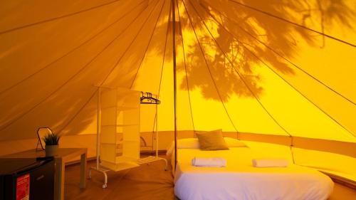 费罗尔Glamping Atlántico的帐篷内一间卧室,配有一张床