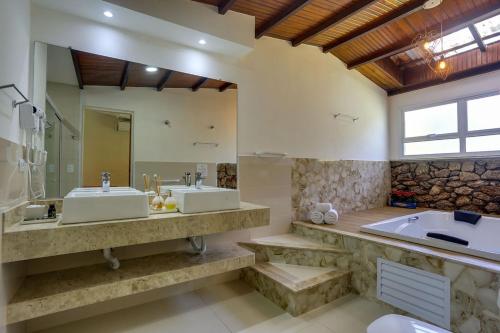 圣埃斯皮里图-皮尼亚尔Pousada Famiglia Bartho的浴室配有2个盥洗盆和1个浴缸。