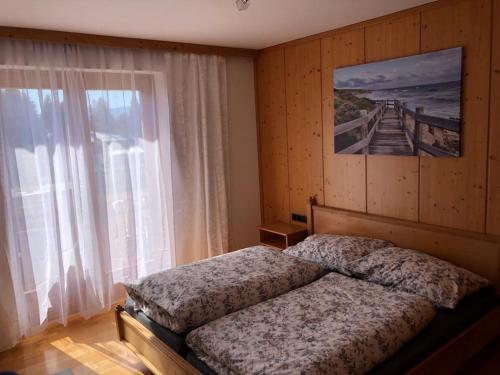 费尔德基兴Haus Gruber的一间卧室设有一张床和一个大窗户