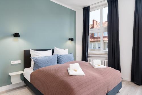 希尔德斯海姆FLATLIGHT: Hildesheim Angoulemeplatz的一间卧室配有一张大床和两条毛巾
