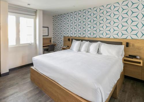红木城Kasa Niche Hotel Redwood City的一间卧室配有一张白色大床和蓝色的墙壁