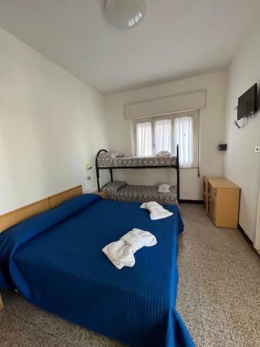 里米尼Mehari Hotel Rimini的一间卧室配有蓝色的床和毛巾