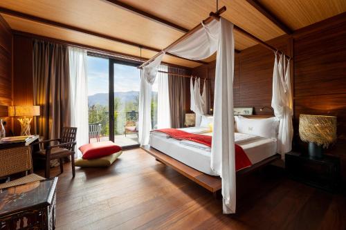蒙塔尼亚Manna Resort的一间卧室设有一张带大窗户的天蓬床