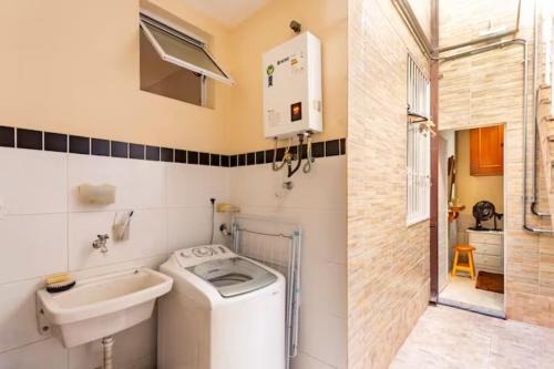 里约热内卢Quarto em casa de vila em Botafogo, Rio de Janeiro的一间带洗衣机和水槽的浴室