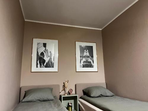 瓦拉日丁Jourek Apartment的卧室配有两张床,墙上挂有两张照片