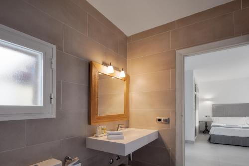 埃斯普霍斯Alojamientos Turísticos Cardona - Estudio Doble Superior的一间带水槽和镜子的浴室以及一张床