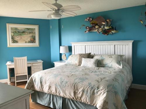 塔维涅Tropical Daze Oceanfront Paradise的蓝色卧室配有床和吊扇