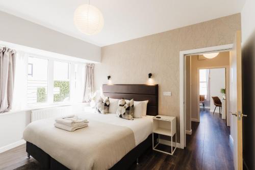 莱瑟姆-圣安妮Design Suites Lytham的一间卧室设有一张大床和一个窗户。