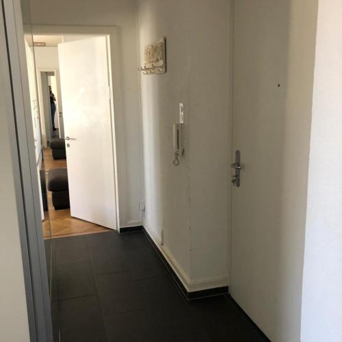 苏黎世Ein Zimmer in einer 2-Zimmer-Wohnung im Zentrum的走廊设有两扇白色门和镜子